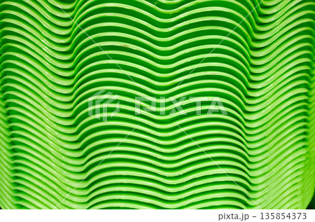 Stacked Green Plastic Plates with Wavy Texture Pattern Background Stacked Green Plastic Plates with Wavy Texture Pattern Background 135854373