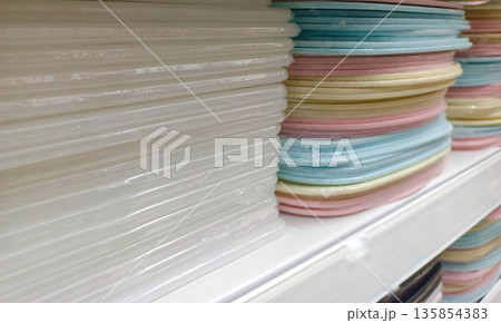 Stacked Colorful Plastic Trays and Cutting Boards on Retail Shelf 135854383