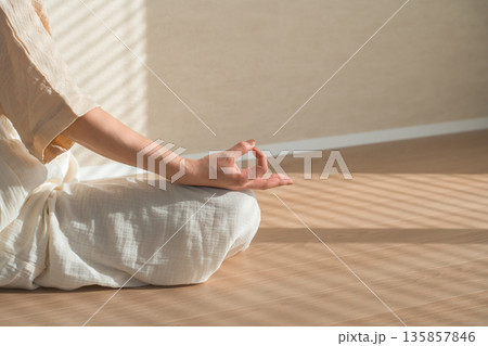 家のリビングでヨガをする女性（リラックス,ヘルスケア,瞑想） 135857846