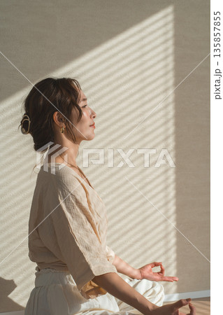 家のリビングでヨガをする女性（リラックス,ヘルスケア,瞑想） 135857855