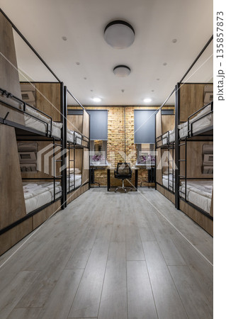 Symmetrical night view of a modern loft hostel dormitory with bunk beds 135857873