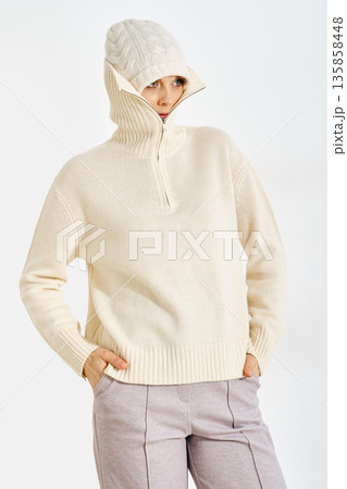 Warm weather wear for cold days in urban setting featuring a woman in a knitted sweater and hat Warm weather wear for cold days in urban setting featuring a woman in a knitted sweater and hat 135858448