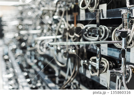 Rows of sleek chrome faucets displayed in a showroom, representing modern bathroom and kitchen design 135860316