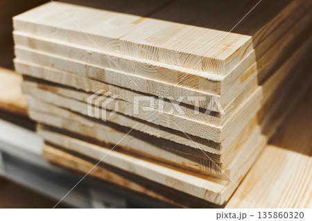 Stack Of Freshly Cut Pine Planks With Visible Grain, Representing Building Materials Stack Of Freshly Cut Pine Planks With Visible Grain, Representing Building Materials 135860320