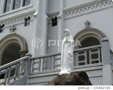 長崎県平戸市紐差町、東洋でも指折りのロマネスク様式の教会、カトリック紐差教会の前に立つマリア像 135862330