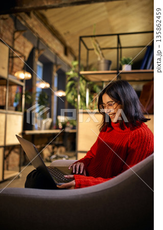 Young woman working on laptop in modern coworking space. Young woman working on laptop in modern coworking space. 135862459