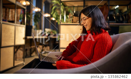 Female professional working on laptop in modern coworking space. 135862462