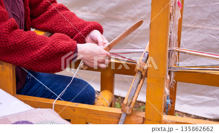 Artisan weaving traditional patterned belt on loom Artisan weaving traditional patterned belt on loom 135862662