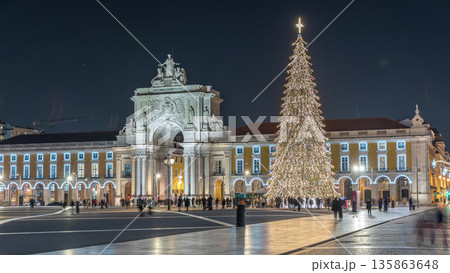 Commerce Square in Lisbon illuminated at Christmas hyperlapse, with a towering tree and crowds celebrating at night. Portugal Commerce Square in Lisbon illuminated at Christmas hyperlapse, with a towering tree and crowds celebrating at night. Portugal 135863648