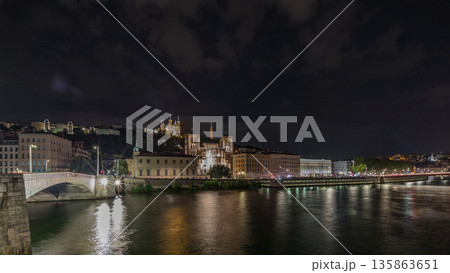 Panorama showing night timelapse of Lyon's cityscape with the red suspension footbridge over the Saone River. France Panorama showing night timelapse of Lyon's cityscape with the red suspension footbridge over the Saone River. France 135863651