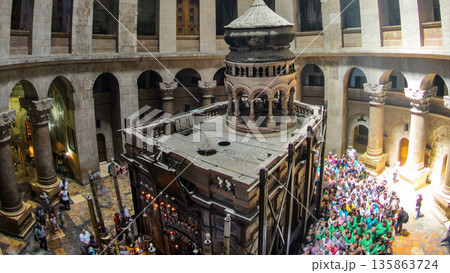Crowd of people and ray of sun from dome in the Church of the Holy Sepulcher timelapse. 135863724
