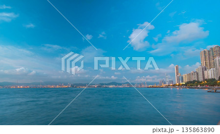 Hong Kong, China skyline panorama day to night from across Victoria Harbor timelapse. 135863890