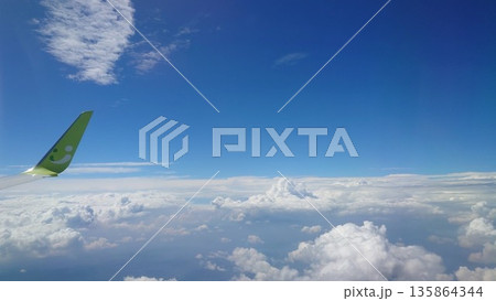 飛行機の翼と青空に浮かぶ雲の風景 飛行機の翼と青空に浮かぶ雲の風景 135864344