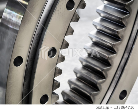 Close-up view of gear mechanism showing teeth and holes in mechanical equipment 135864716