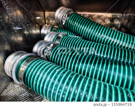 Hoses arranged in a storage area for use in industrial applications and maintenance tasks during daytime Hoses arranged in a storage area for use in industrial applications and maintenance tasks during daytime 135864719