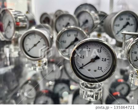 Close view of pressure gauges on display at an industrial fair showing various measurements in a trade exhibition setting Close view of pressure gauges on display at an industrial fair showing various measurements in a trade exhibition setting 135864721