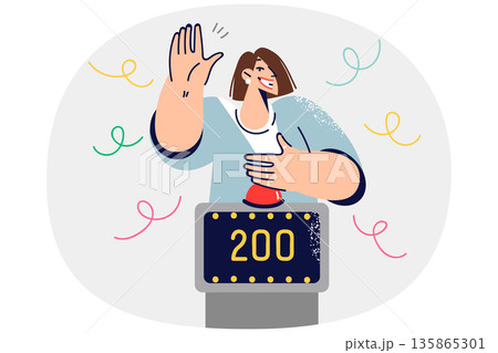 Woman participating in TV show with quiz game raises hand to press button, stands near point counter Woman participating in TV show with quiz game raises hand to press button, stands near point counter 135865301
