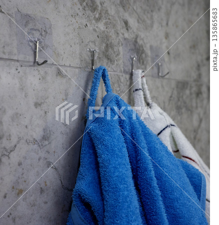 Terry bathrobes hang on hooks in the bathroom Terry bathrobes hang on hooks in the bathroom 135865683