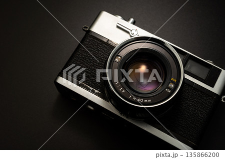暗い背景にスポットライトが当たった古いフィルムカメラ 暗い背景にスポットライトが当たった古いフィルムカメラ 135866200