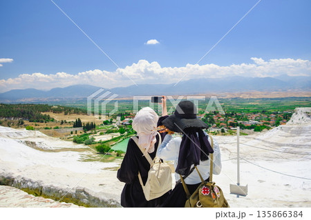 Woman with her friend taking a photo of the beautiful landscape. tourist capture selfie together 135866384