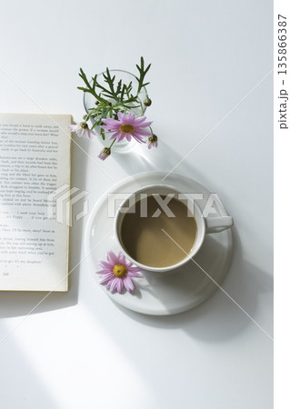 余白たっぷりの白いテーブル　カフェラテとマーガレットと読書（縦） 135866387