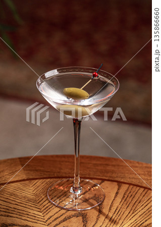 Clear martini cocktail with olive garnish Clear martini cocktail with olive garnish 135866660