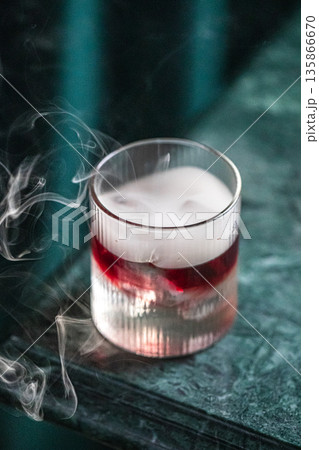 Layered cocktail with smoke in textured glass Layered cocktail with smoke in textured glass 135866670