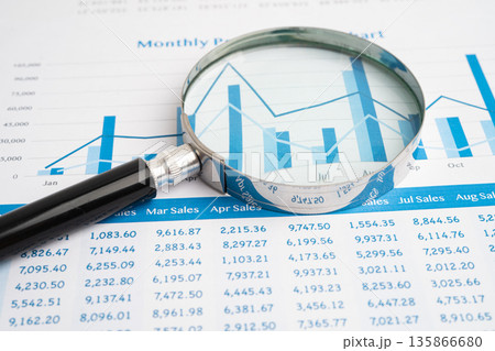 Magnifying glass on data business graphs paper. 135866680