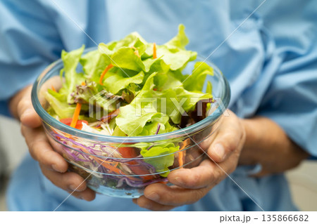 Asian Nutritionist holding salad vegetable healthy food for patient, nutrition and vitamin. 135866682
