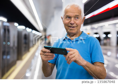Old man with smartphone in subway station 135867048