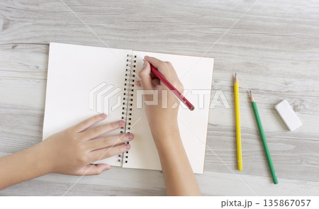 ノートに文字またはイラストを書く子供 ノートに文字またはイラストを書く子供 135867057