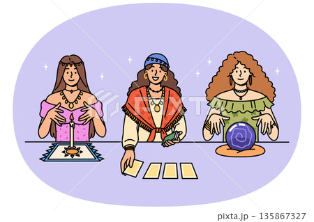 Female fortune tellers use tarot cards and oracle crystal ball to predict future 135867327