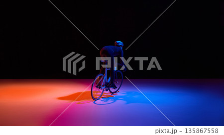 High performance cycling athlete in dynamic neon studio scene. High performance cycling athlete in dynamic neon studio scene. 135867558