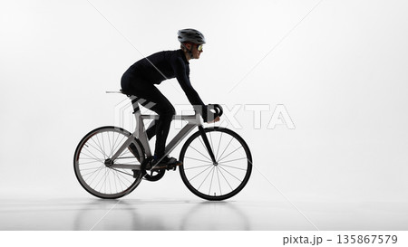 Professional cyclist riding road bike in studio isolated on white background. Professional cyclist riding road bike in studio isolated on white background. 135867579