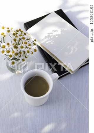 木漏れ日の白いテーブル　コーヒーとマトリカリアとノート（余白） 135868193