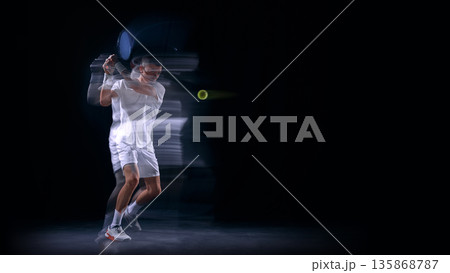Tennis backhand swing with motion trails on dark background. 135868787