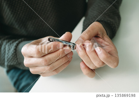 nail trimming seated at a table nail trimming seated at a table 135869198