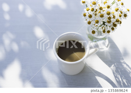 木漏れ日の白いテーブル　コーヒーとマトリカリアとノート（横・余白） 135869624