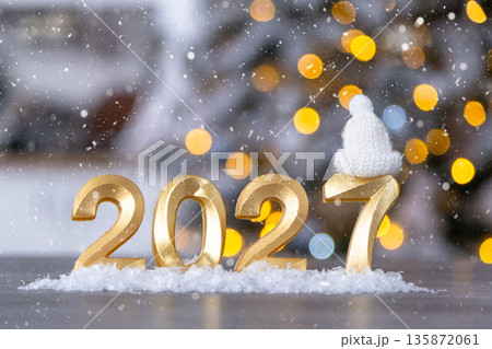 Golden figures number 2027 New Year against the background of fairy light, snow and garlands. Greeting card, Happy New Year, cozy home 135872061