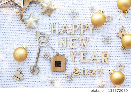 House key with keychain cottage on festive background with stars, lights of garlands. New Year 2027 wooden letters, greeting card. Purchase, construction, relocation, mortgage, insurance House key with keychain cottage on festive background with stars, lights of garlands. New Year 2027 wooden letters, greeting card. Purchase, construction, relocation, mortgage, insurance 135872080