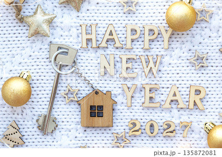 House key with keychain cottage on festive background with stars, lights of garlands. New Year 2027 wooden letters, greeting card. Purchase, construction, relocation, mortgage, insurance House key with keychain cottage on festive background with stars, lights of garlands. New Year 2027 wooden letters, greeting card. Purchase, construction, relocation, mortgage, insurance 135872081