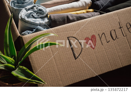 Box filled with neatly folded clothes ready for donation at a local charity for those in need 135872217