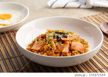 Kimchi fried rice with bacon topped with sesame seed and Crispy Seaweed in white plate.Korean food. Kimchi fried rice with bacon topped with sesame seed and Crispy Seaweed in white plate.Korean food. 135872544