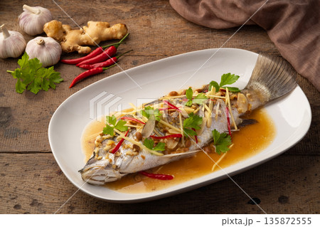 Steamed Seabass fish with Soybean Paste sauce in white plate Steamed Seabass fish with Soybean Paste sauce in white plate 135872555