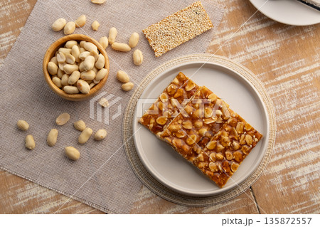 Chinese Peanut and Sesame Bar,Peanut brittle crisp candy in a plate.Thai snack.Top view. Chinese Peanut and Sesame Bar,Peanut brittle crisp candy in a plate.Thai snack.Top view. 135872557