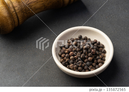 fragrant spices ,black peppercorn in white bowl background 135872565