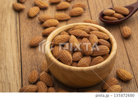 Dry roasted Almonds in wooden bowl on wooden table.Heap of almond. 135872680
