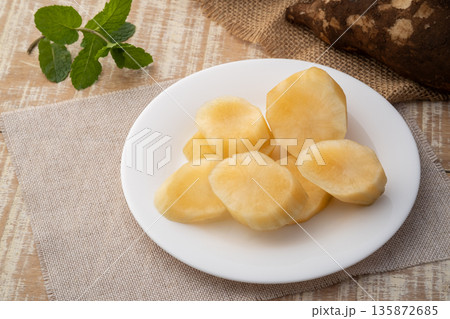 Close up peeled Yacon root fruit(Smallanthus sonchifolius) in white plate on wooden table. 135872685