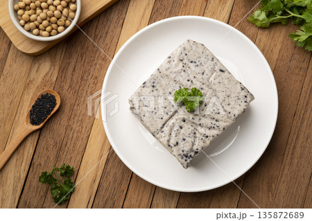 Tofu mix black sesame seeds in white plate on wooden table.Top view 135872689