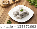 Sliced piece of Tofu mix black sesame seeds in white plate on wooden table 135872692
